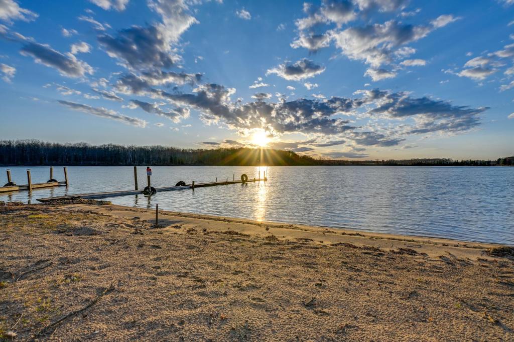 um pôr-do-sol sobre um lago com uma doca em Lake Home with Private Dock Steps to Sandy Beach! em Lake