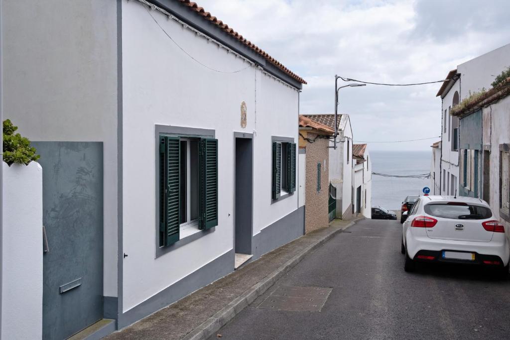 un coche blanco estacionado en una calle al lado de los edificios en Casa Dona Isaura, en Ponta Delgada