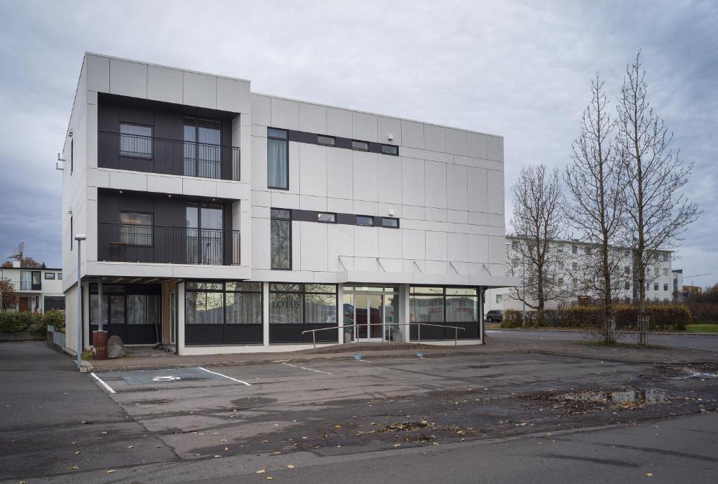un parcheggio vuoto di fronte a un edificio di Hotel Lotus a Reykjavik
