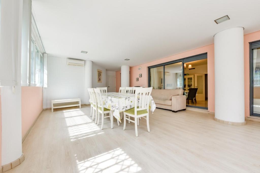 Un comedor con mesa y sillas en Enorme apartamiento en CALA ALTA de Villajoyosa, en Cala de Finestrat