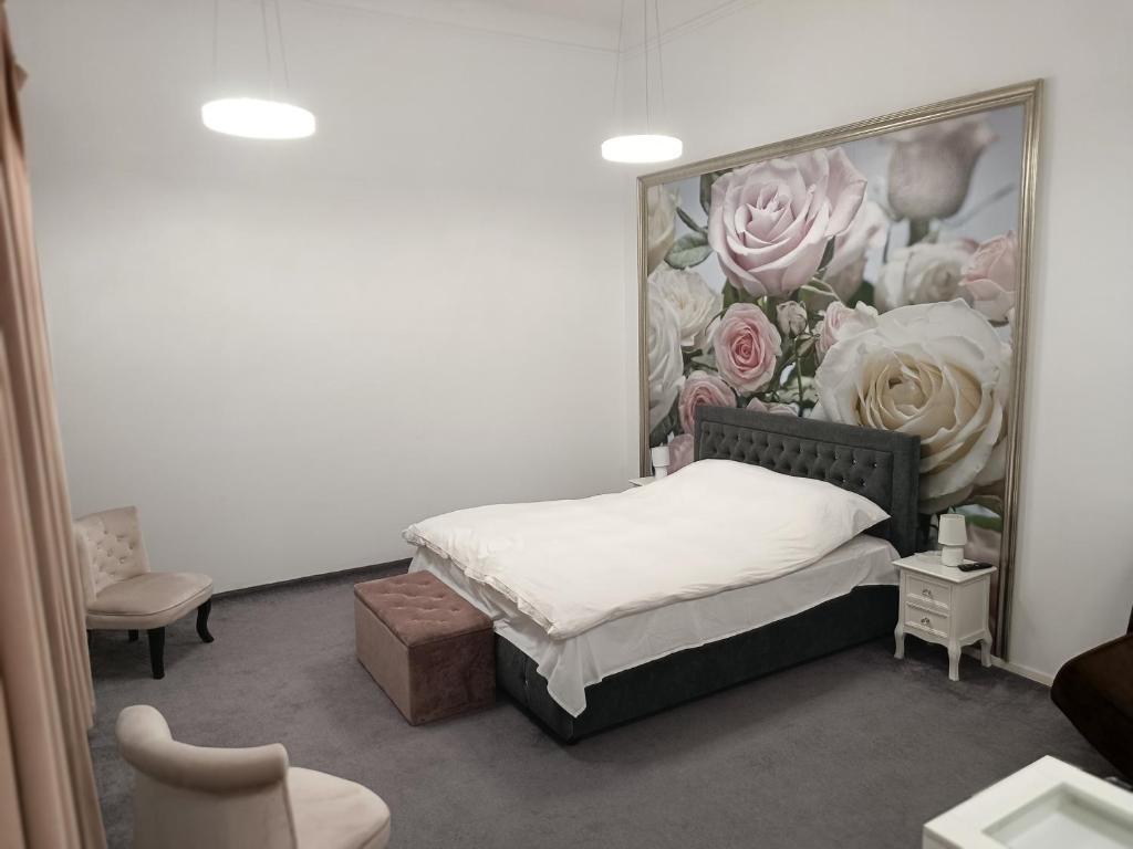 een slaapkamer met een bed met een schilderij van rozen bij Samuel House in Sibiu