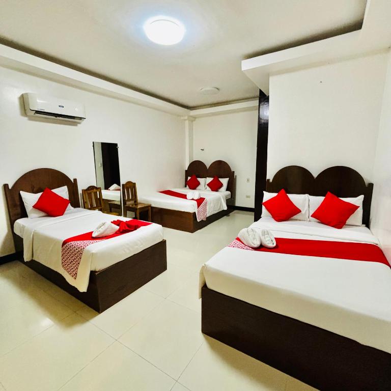 a bedroom with two beds with red pillows at Fatchoi Hotel in General Santos