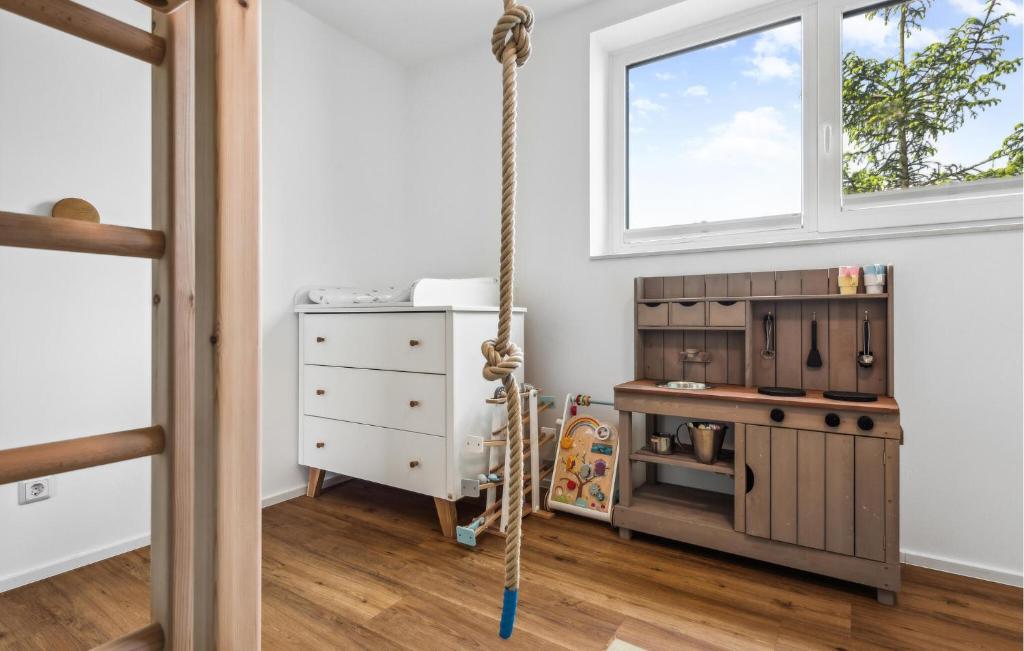 a swing in a room with a play kitchen at Awesome Home In Lembruch-dmmer See With Sauna in Lembruch