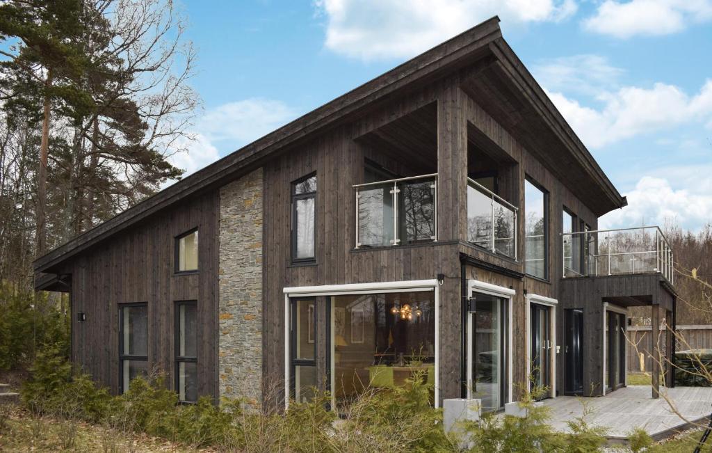 uma casa de madeira com uma varanda em cima em Nice Home In Sandefjord With House Sea View em Sandefjord