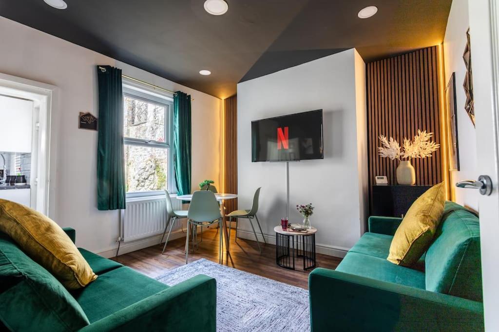 uma sala de estar com dois sofás verdes e uma mesa em 4 Bed House Contractor & Leisure em Preston