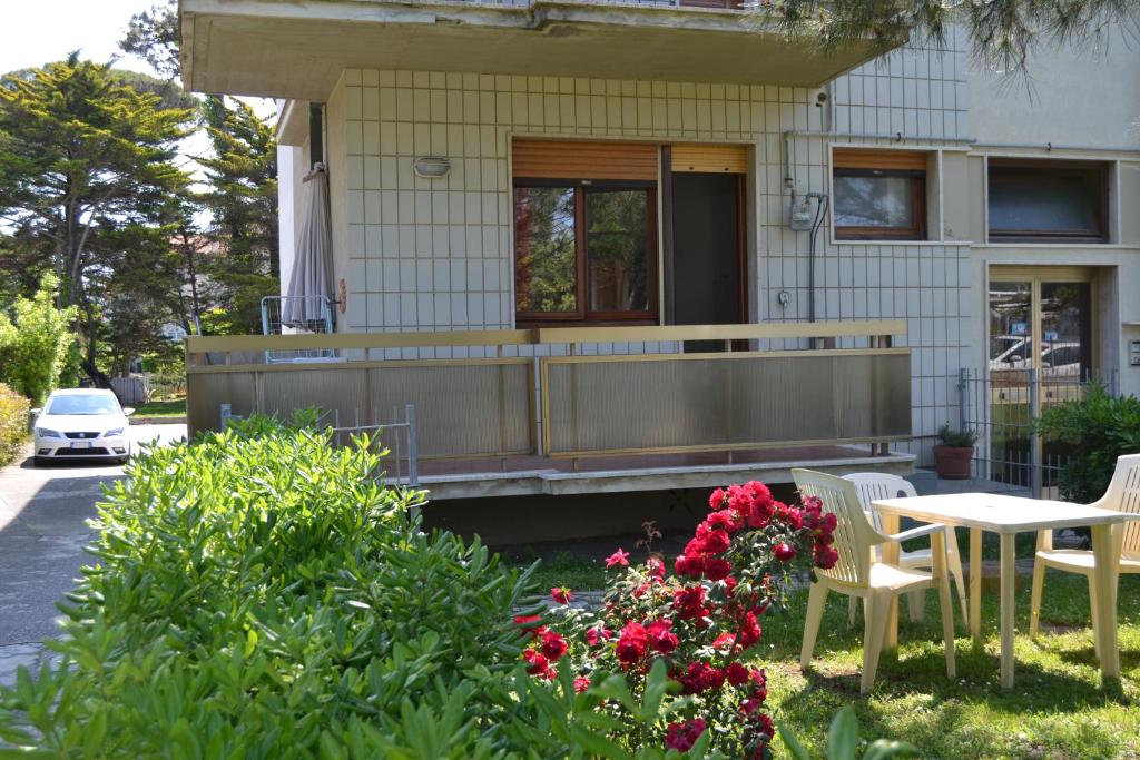 uma casa com mesa, cadeiras e flores em Nettuno Apartament em Tirrenia