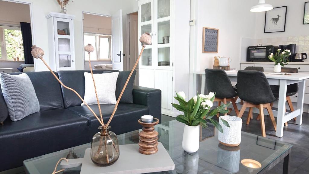 a living room with a couch and a table at huisje Zilvermeeuw in Burgh Haamstede