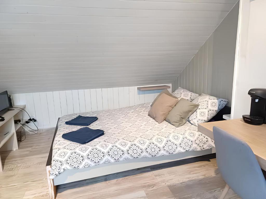 ein kleines Schlafzimmer mit einem Bett mit blauen Handtüchern darauf in der Unterkunft Studio Miraumont, stationnement gratuit, 5min gare in Amiens