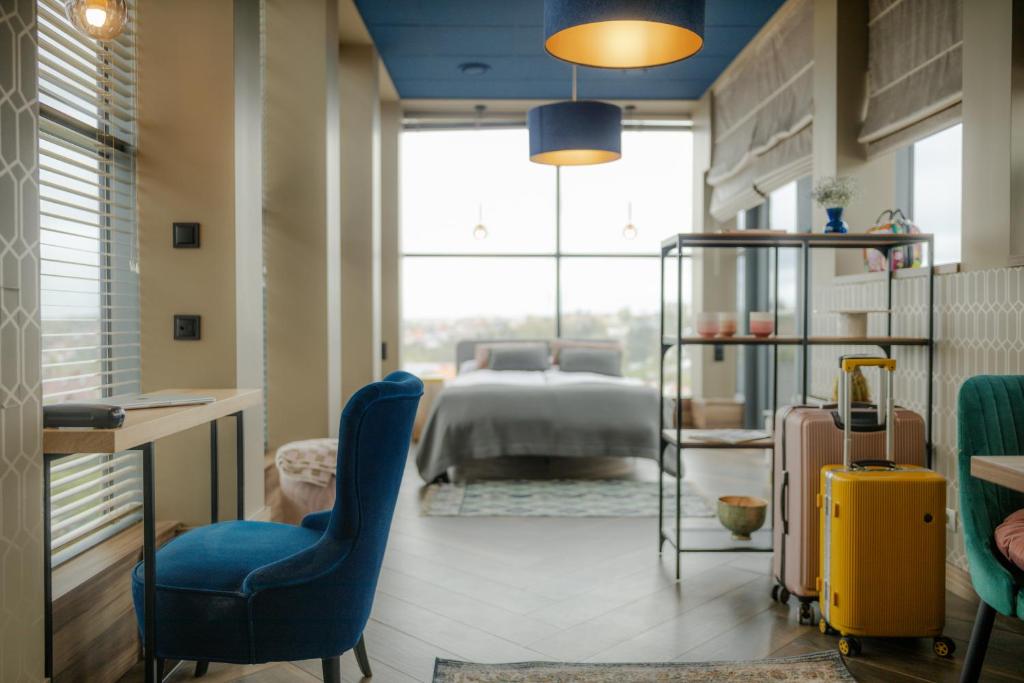 a bedroom with a bed and a yellow suitcase at Hotel Beethoven in Gdańsk