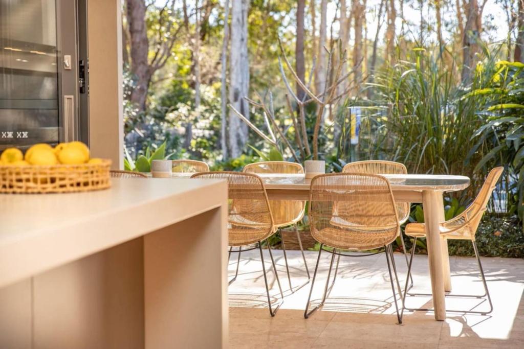 a kitchen with a table and chairs and a patio at Always Summer Boomerang in Boomerang Beach