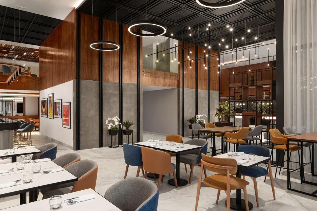 カサブランカにあるCourtyard by Marriott Casablanca Downtownのダイニングルーム(テーブル、椅子、テーブルトップ付)