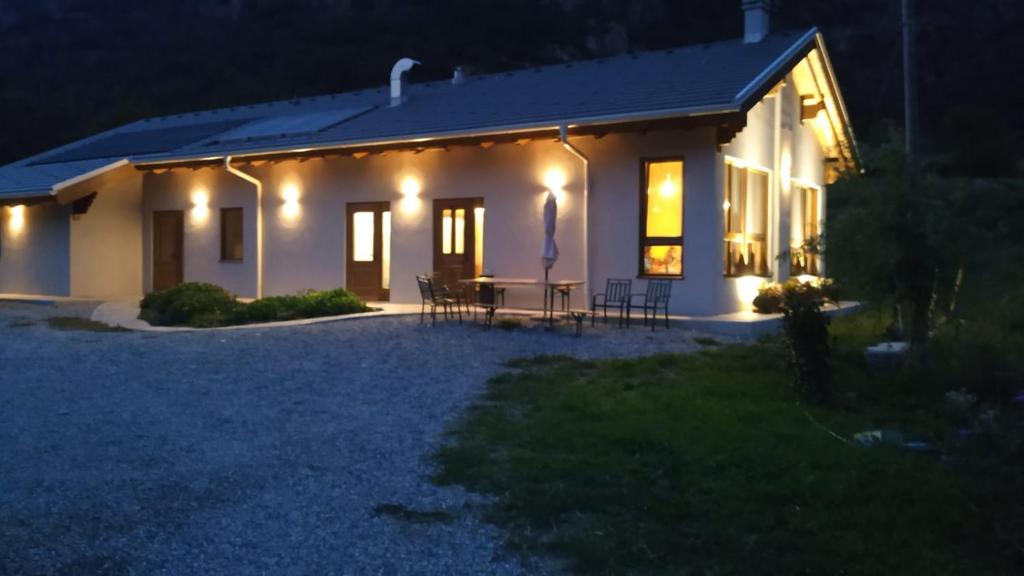 une maison éclairée la nuit avec des lumières allumées dans l'établissement Agriturismo Le Rocher Fleuri, à Bard