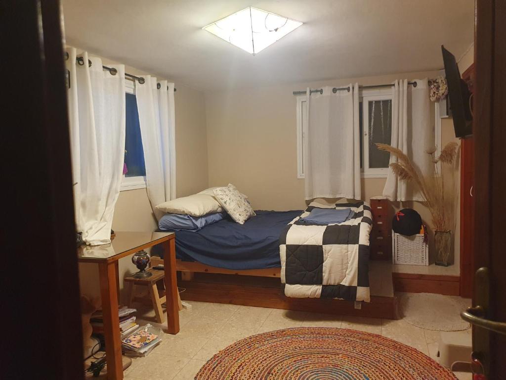 a small bedroom with a bed and a window at הביקתה בגן 