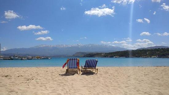 two chairs sitting on a beach near the water at Eleftherias Suites - Near Beach Apartments in Marathi