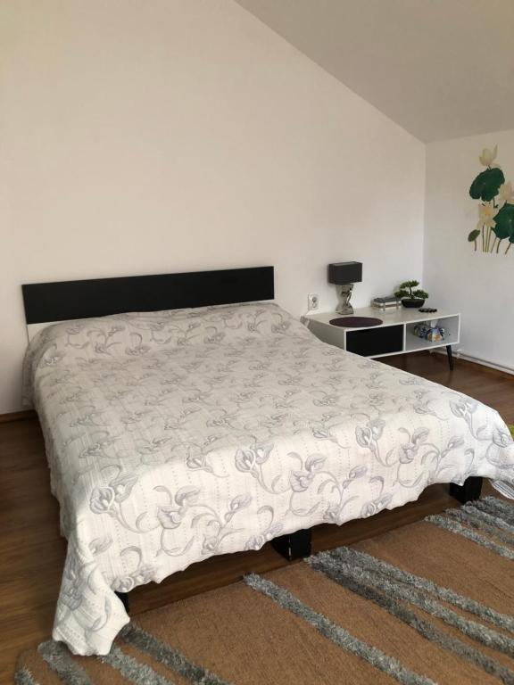 ein Schlafzimmer mit einem großen Bett mit einer weißen Bettdecke in der Unterkunft Casa Rediu Iasi in Iaşi