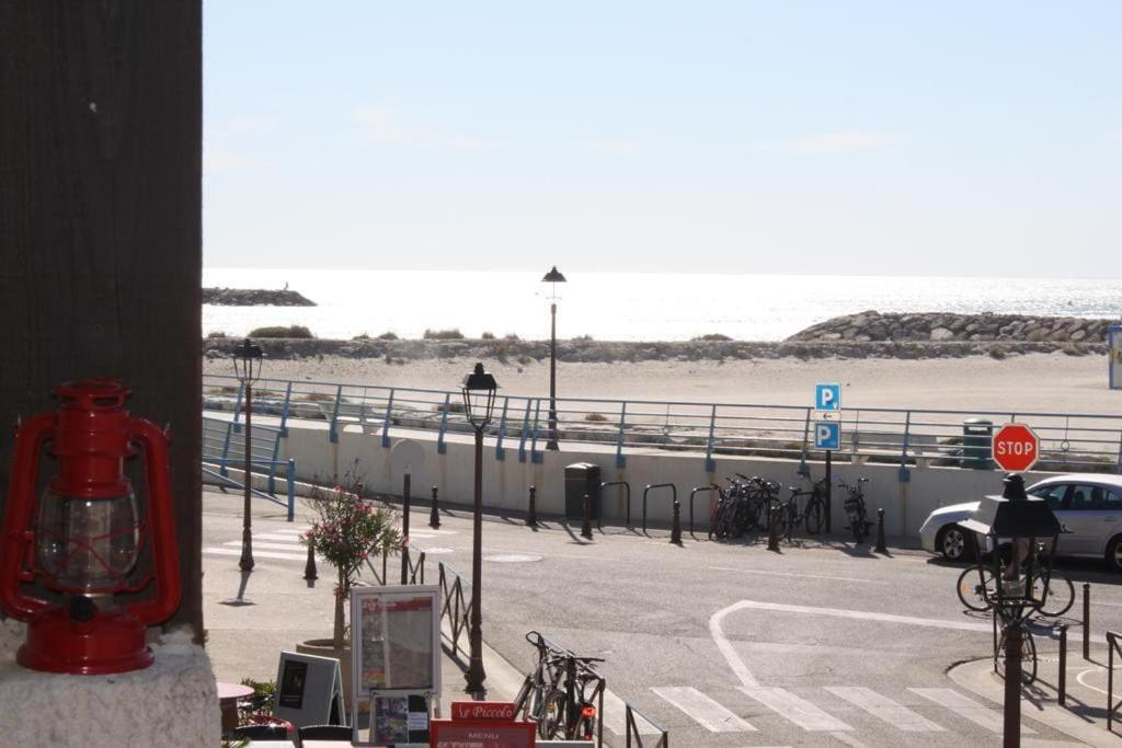 un parking à côté d'une plage avec une voiture dans l'établissement Bel appart vue mer proche centre, climatisation, à Saintes-Maries-de-la-Mer