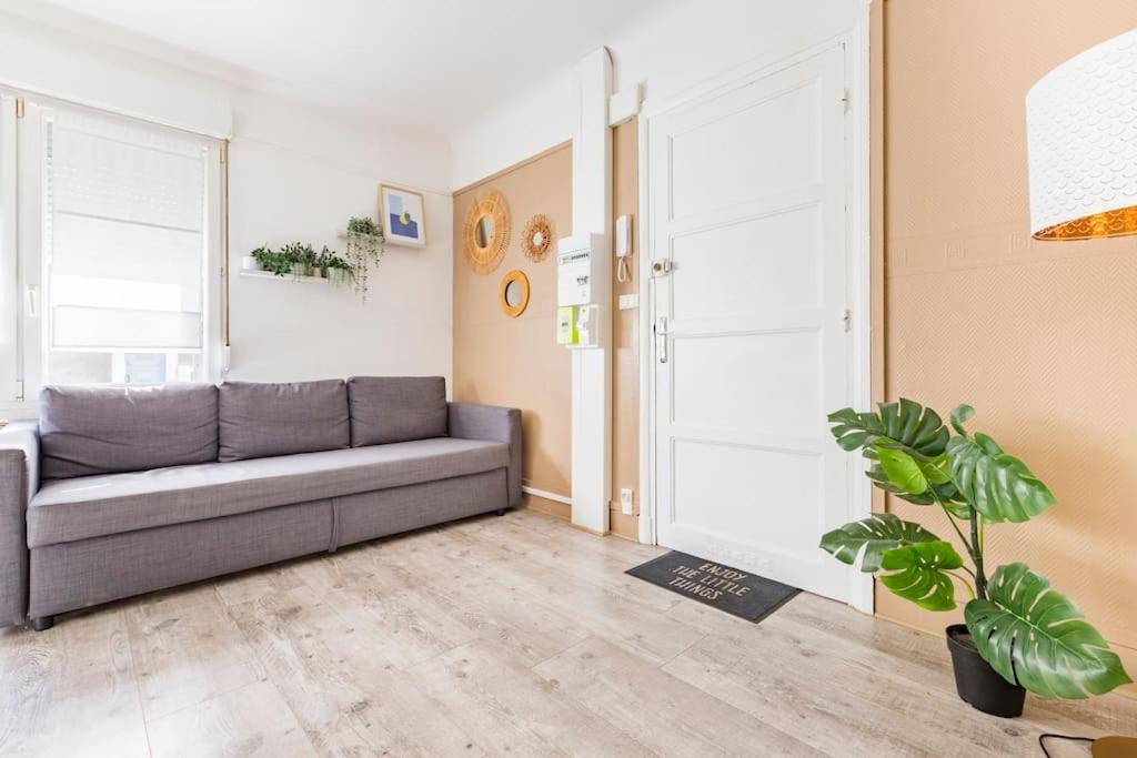 un salon avec un canapé et une plante en pot dans l'établissement Appartement moderne Boulogne sur Mer proche de la plage et Nausicaa, à Boulogne-sur-Mer