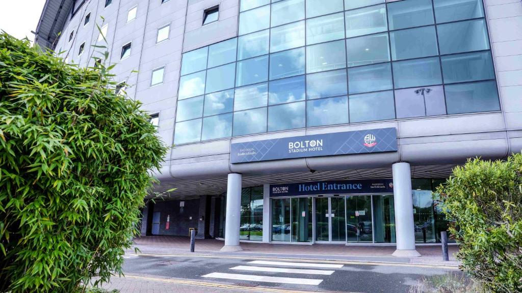 a building with a sign on the front of it at Bolton Stadium Hotel in Bolton