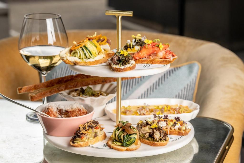 a three tiered plate of food and a glass of wine at Kimpton Hotel Theta, an IHG Hotel in New York
