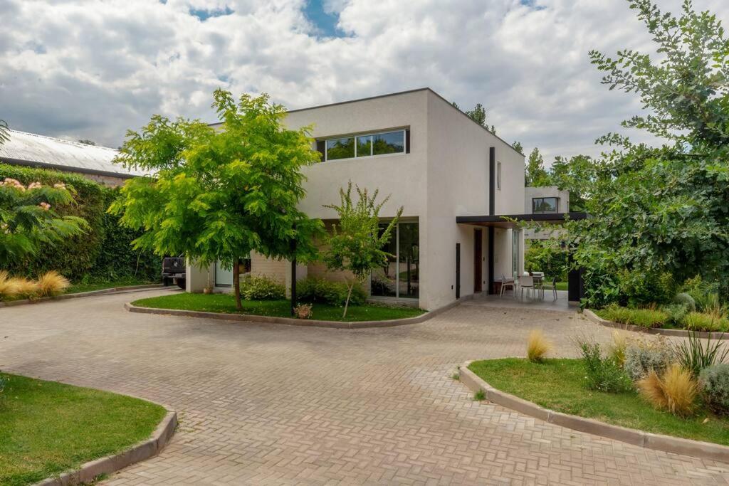 ein weißes Haus mit Auffahrt in der Unterkunft The Acacia Village in Ciudad Lujan de Cuyo