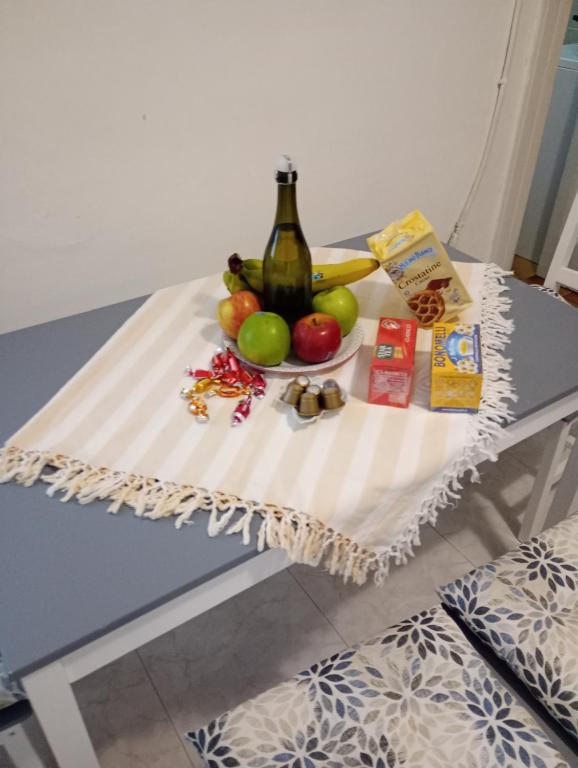 a table with a bowl of fruit and a bottle of wine at Casa Mariella in Bari