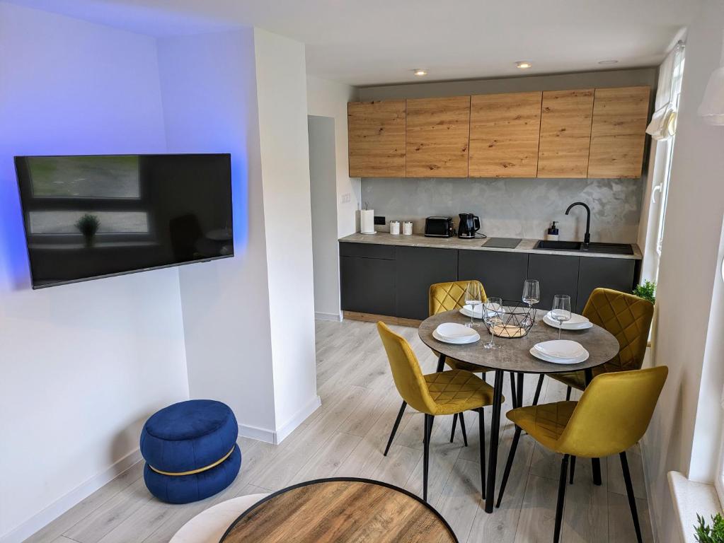 a kitchen and dining room with a table and chairs at White Shell Apartament Hel in Hel