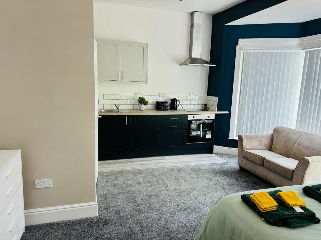 ein Wohnzimmer mit einem Sofa und einer Küche in der Unterkunft Manzil by HeyHouseLife in Middlesbrough