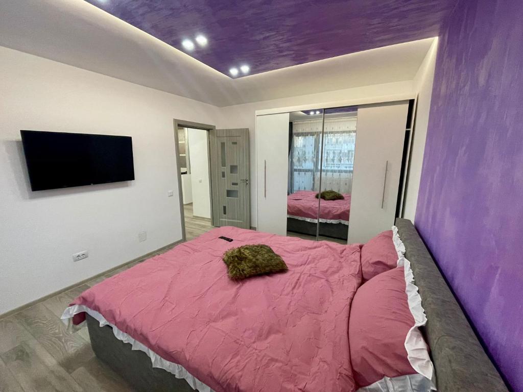 - une chambre avec un lit au plafond violet dans l'établissement D&D New Residence, à Piteşti