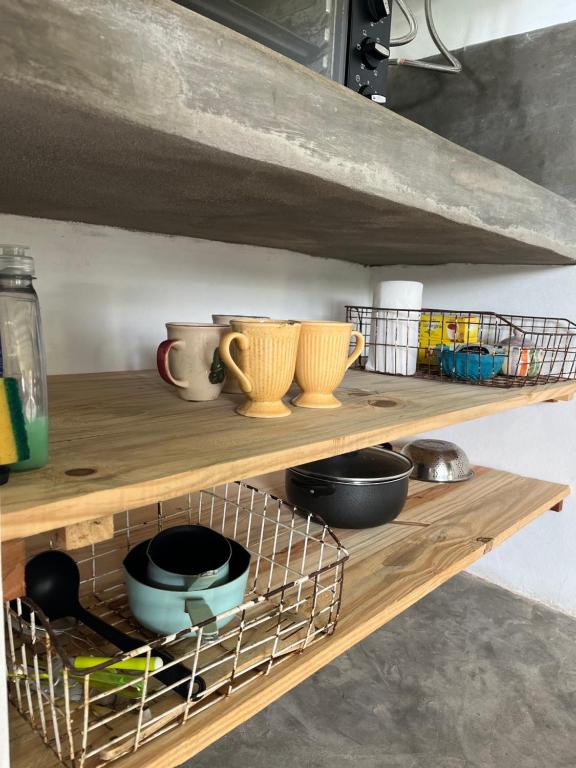 a shelf with bowls and utensils on it at El Garzal in Mercedes