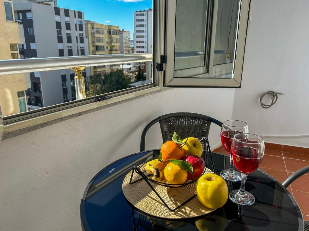 een tafel met een fruitschaal en een glas wijn bij Vacation 988 in Durrës