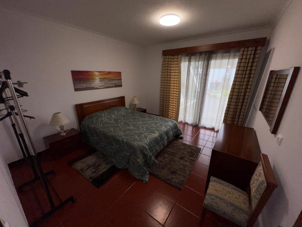 a bedroom with a bed and a window at Alojamento Vila Flor in Praia da Vitória