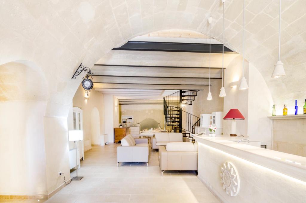 una sala de estar con muebles blancos y un arco en Casa Del Sole, en Matera