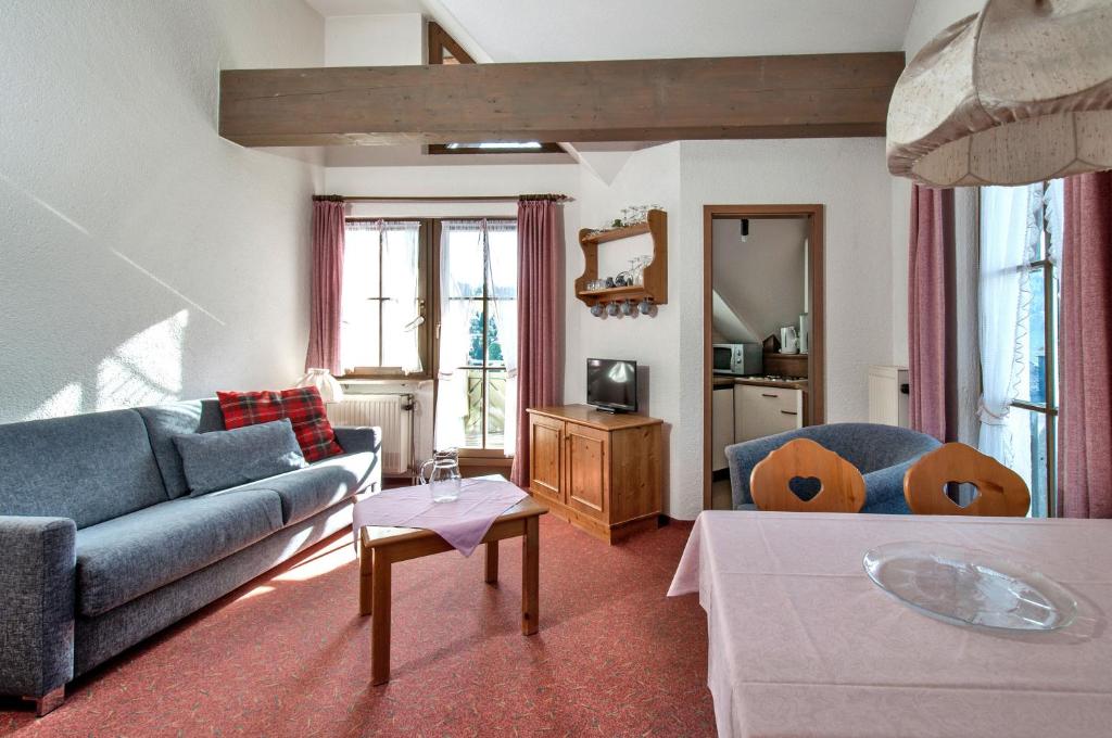 a living room with a couch and a table at Apartment 15 - Ferienresidenz Roseneck, Galeriewohnung, mit Schwimmbad in Todtnauberg bei Feldberg in Todtnauberg
