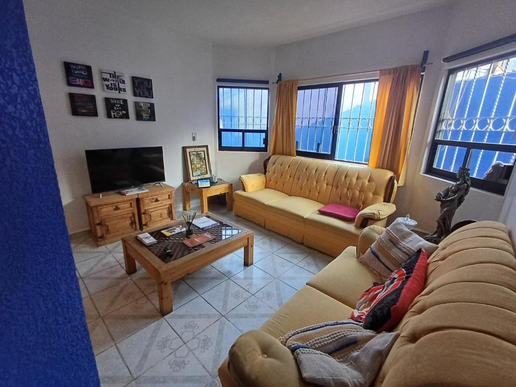 un soggiorno con 2 divani e una TV di Rústica Azul a Tlaxcala de Xicohténcatl