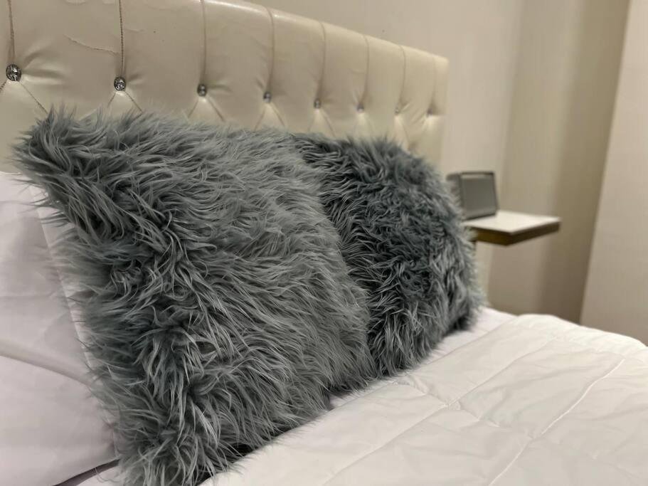 - un oreiller en fourrure gris assis sur un lit dans l'établissement Casa de lujo Altozano Residencial con Piscina by AIRA, 