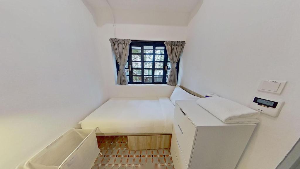 a small room with a bed and a window at Habyt Bridges - 6-8 Wa In Fong Street in Hong Kong
