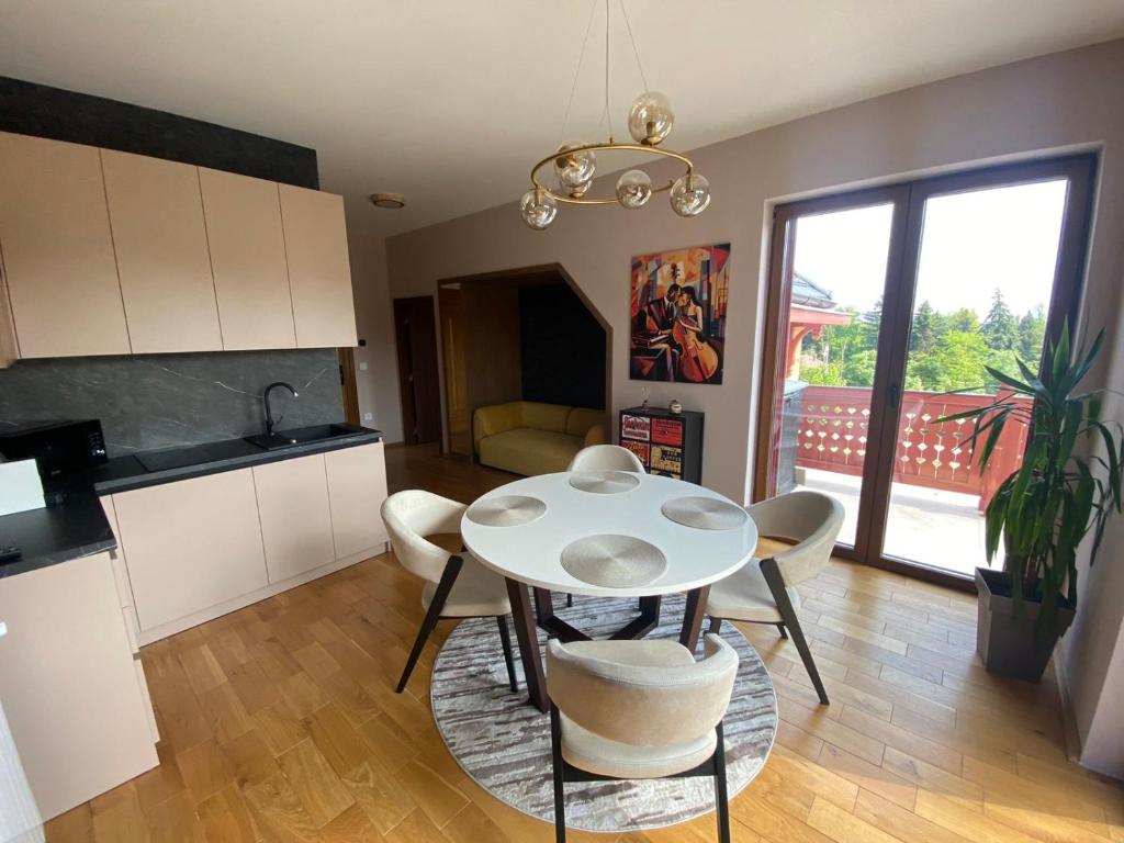 uma cozinha e sala de jantar com mesa e cadeiras em Grand Vista Apartman em Palić