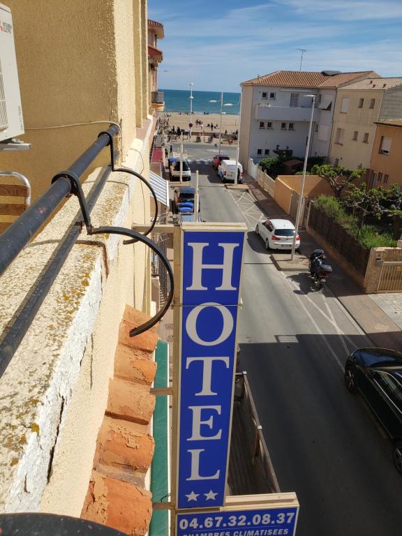 um sinal que lê hotel na lateral de um edifício em Hotel De La Plage em Valras-Plage