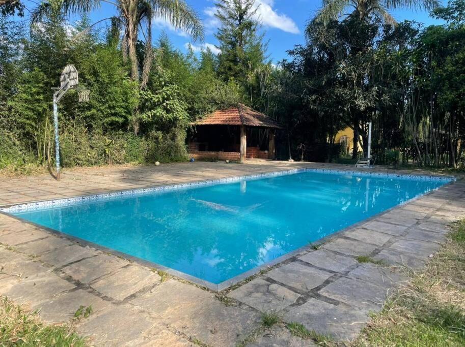 a swimming pool in a yard with a gazebo at Casa amarela in Juiz de Fora