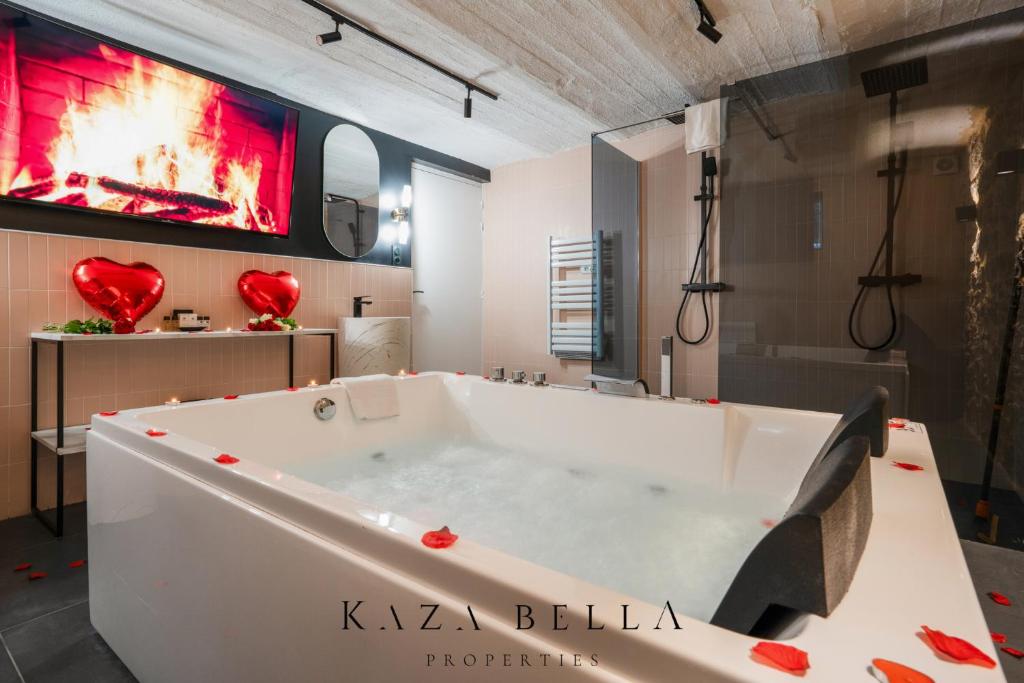 La salle de bains est pourvue d'une grande baignoire et de coeurs rouges sur le mur. dans l'établissement KAZA BELLA - Maisons Alfort 5 Luxurious apartment with private garden and Jacuzzi, à Maisons-Alfort