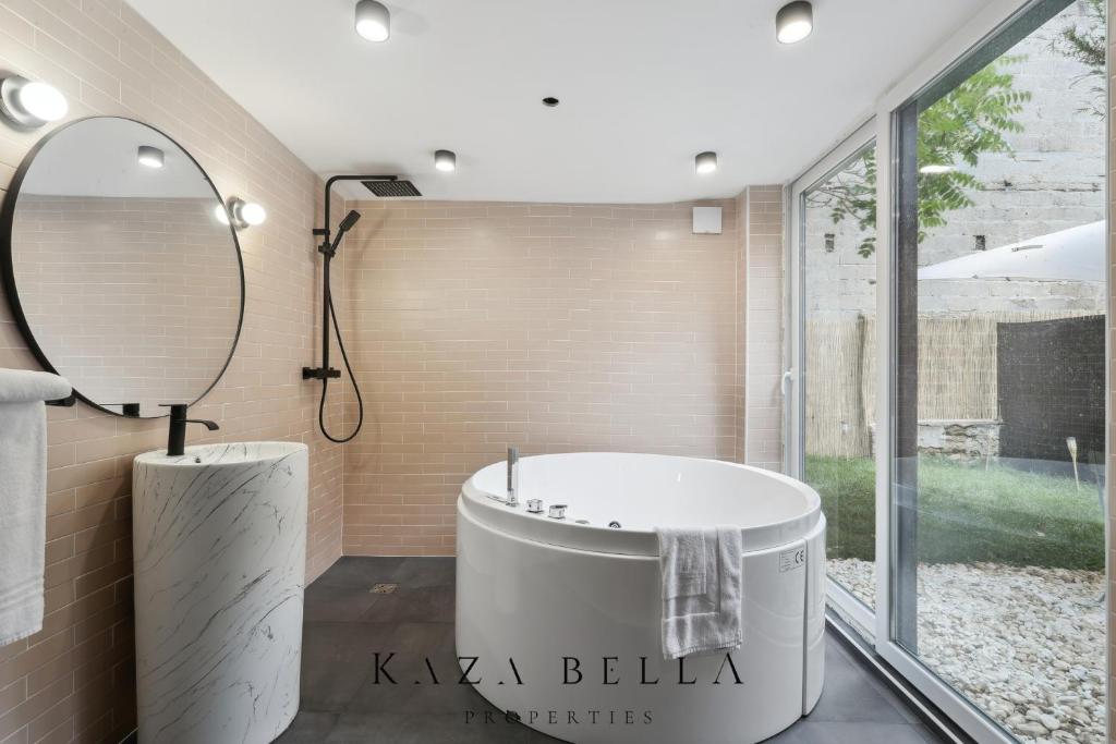 a bathroom with a bath tub and a mirror at KAZA BELLA - Maisons Alfort 6 Luxurious little house with private garden and Jacuzzi in Maisons-Alfort