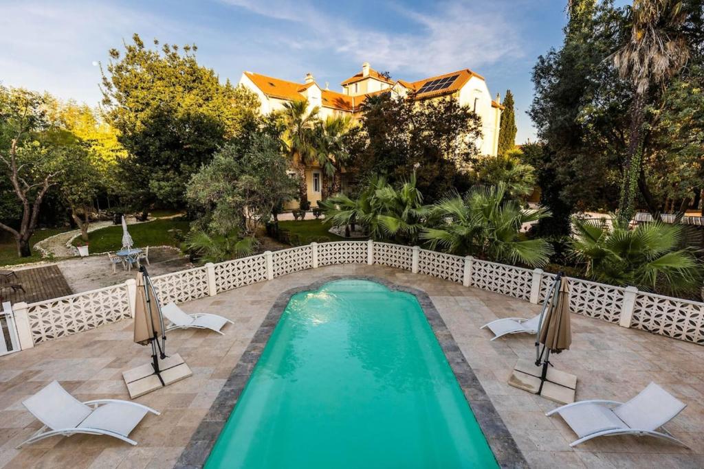 uma piscina com cadeiras e uma casa em 66C2 Unique apartment for 6 in a castle with pool em Perpignan