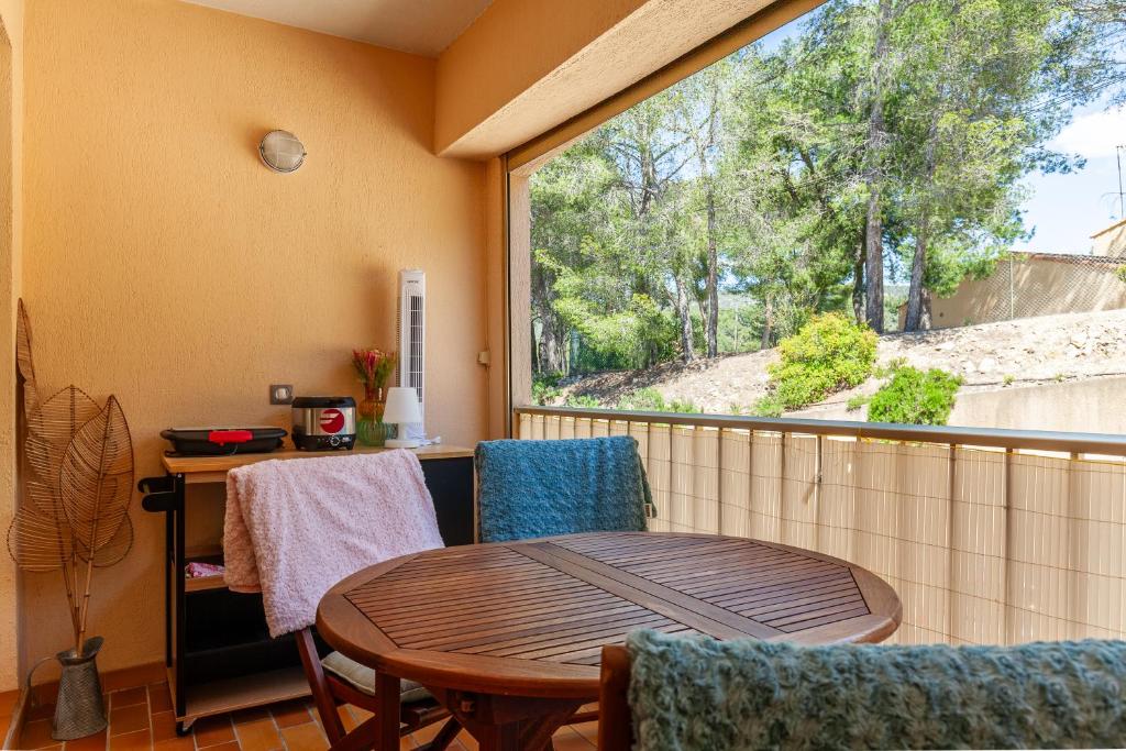un balcon avec une table et des chaises et une grande fenêtre dans l'établissement Studio Sanary, à Sanary-sur-Mer