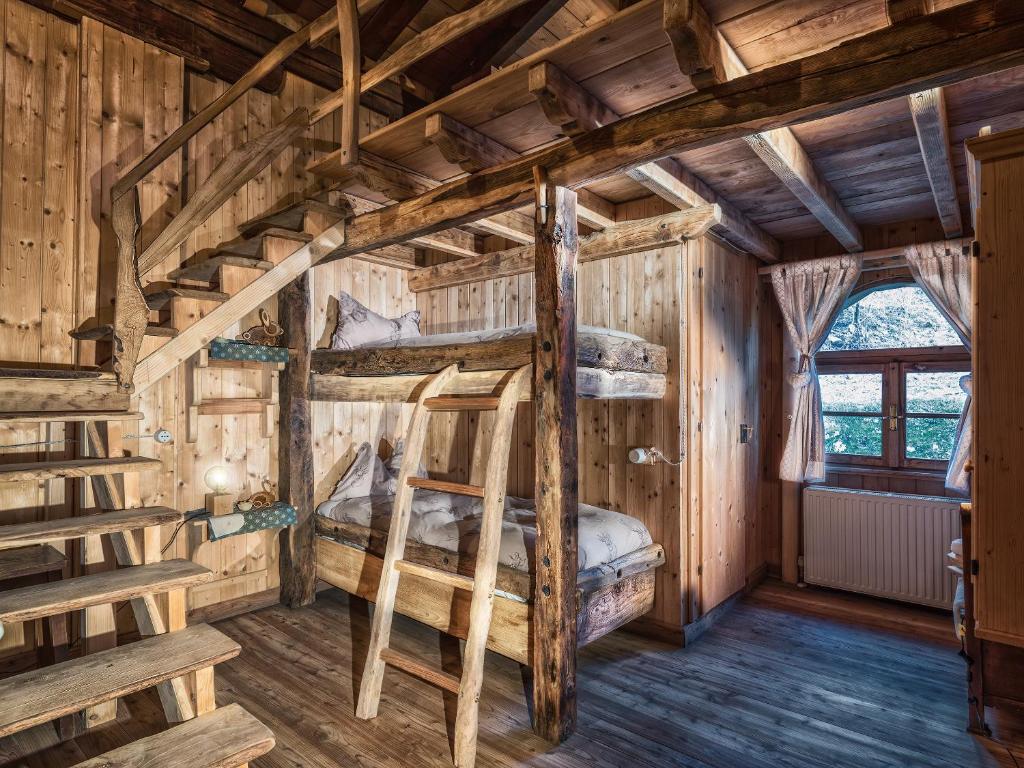 a room with two bunk beds in a log cabin at Agriturismo Randis in Piano dʼArta