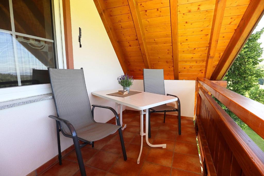 uma pequena mesa e duas cadeiras numa varanda em Budererhof em Freiamt