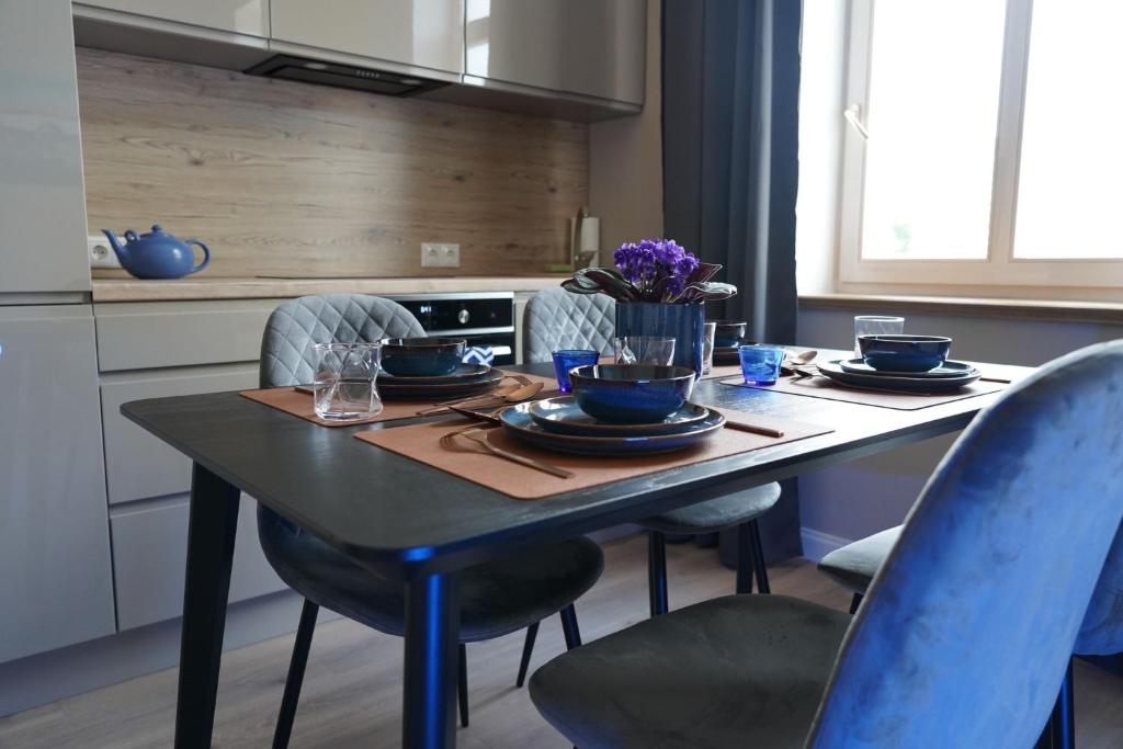 uma cozinha com uma mesa com pratos e tigelas em Giertmaņa apartamenti em Liepāja