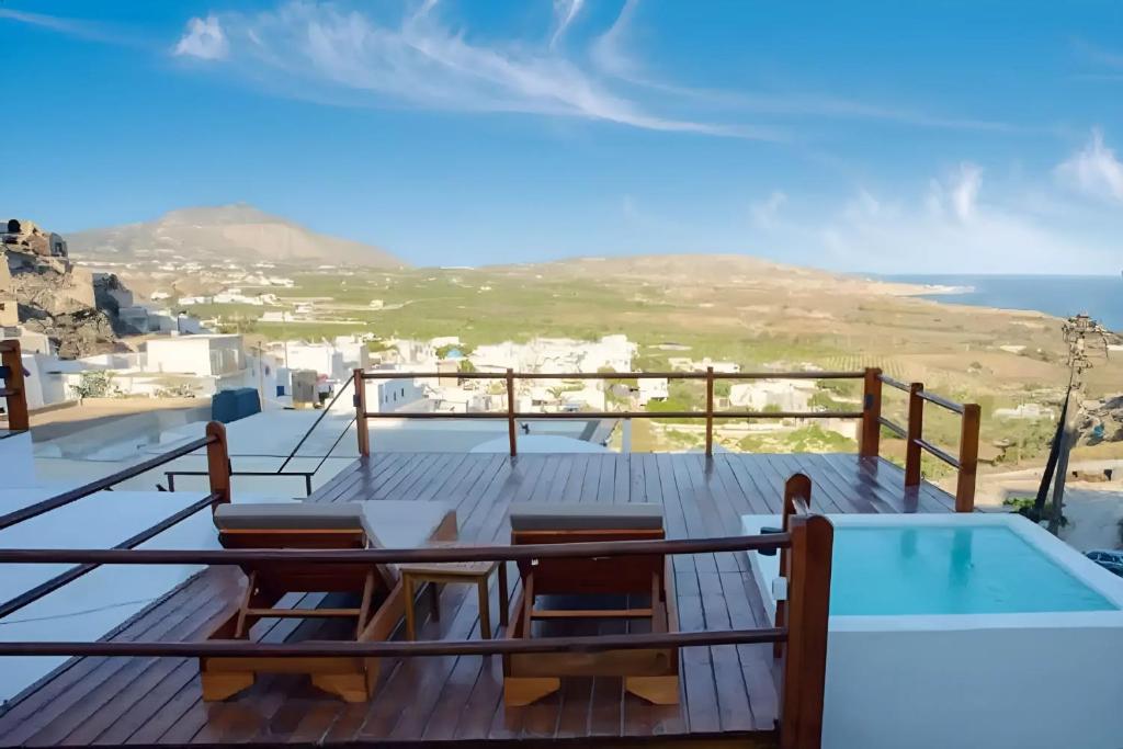 una terraza con mesa y sillas y una piscina en Santorini Rooftop Hot Tub Suite with Panoramic Views en Akrotiri