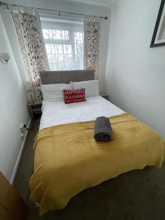 1 dormitorio con 1 cama grande con manta amarilla en Immaculate 3-Bed House in Luton, en Luton