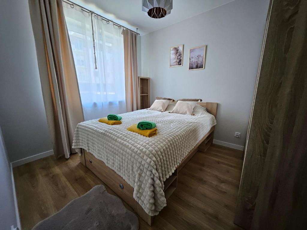 a bedroom with a bed with two bowls on it at Urban Jungle Apartament Brown in Białystok