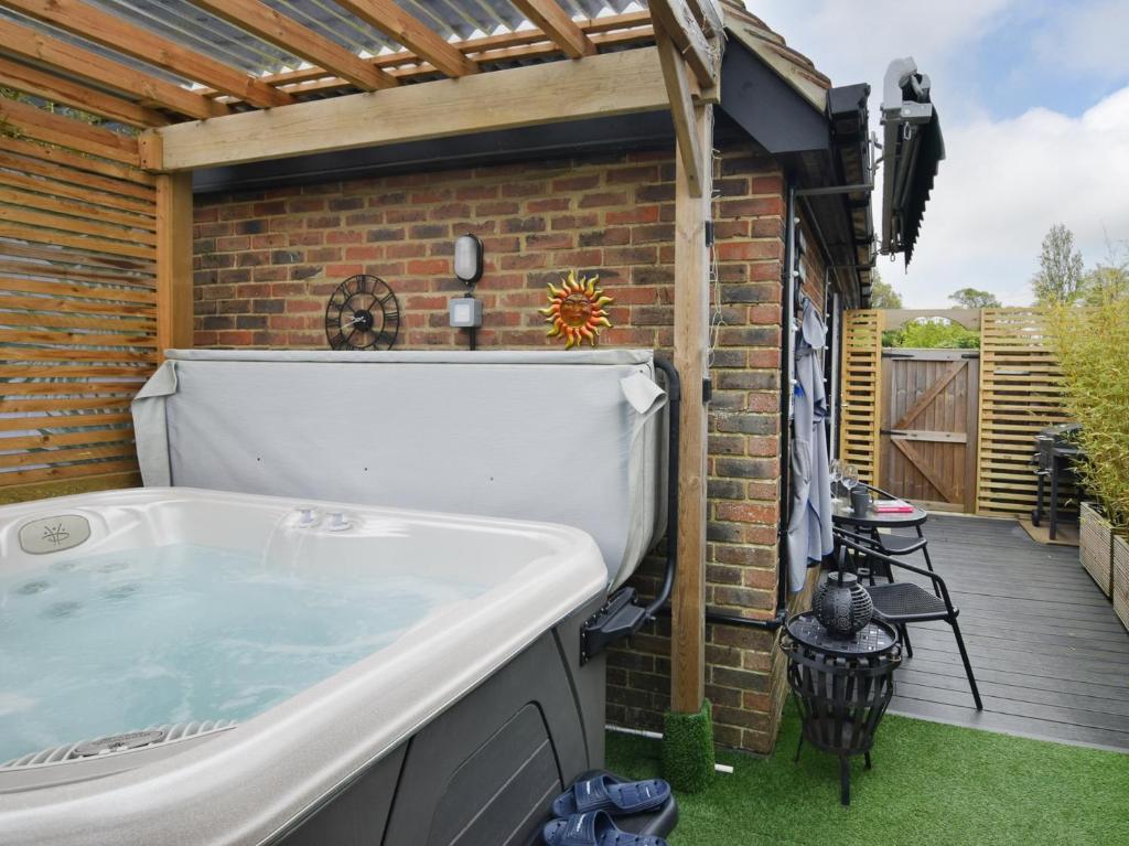 a hot tub in a backyard with a deck at 1 Bed in Sissinghurst 88466 